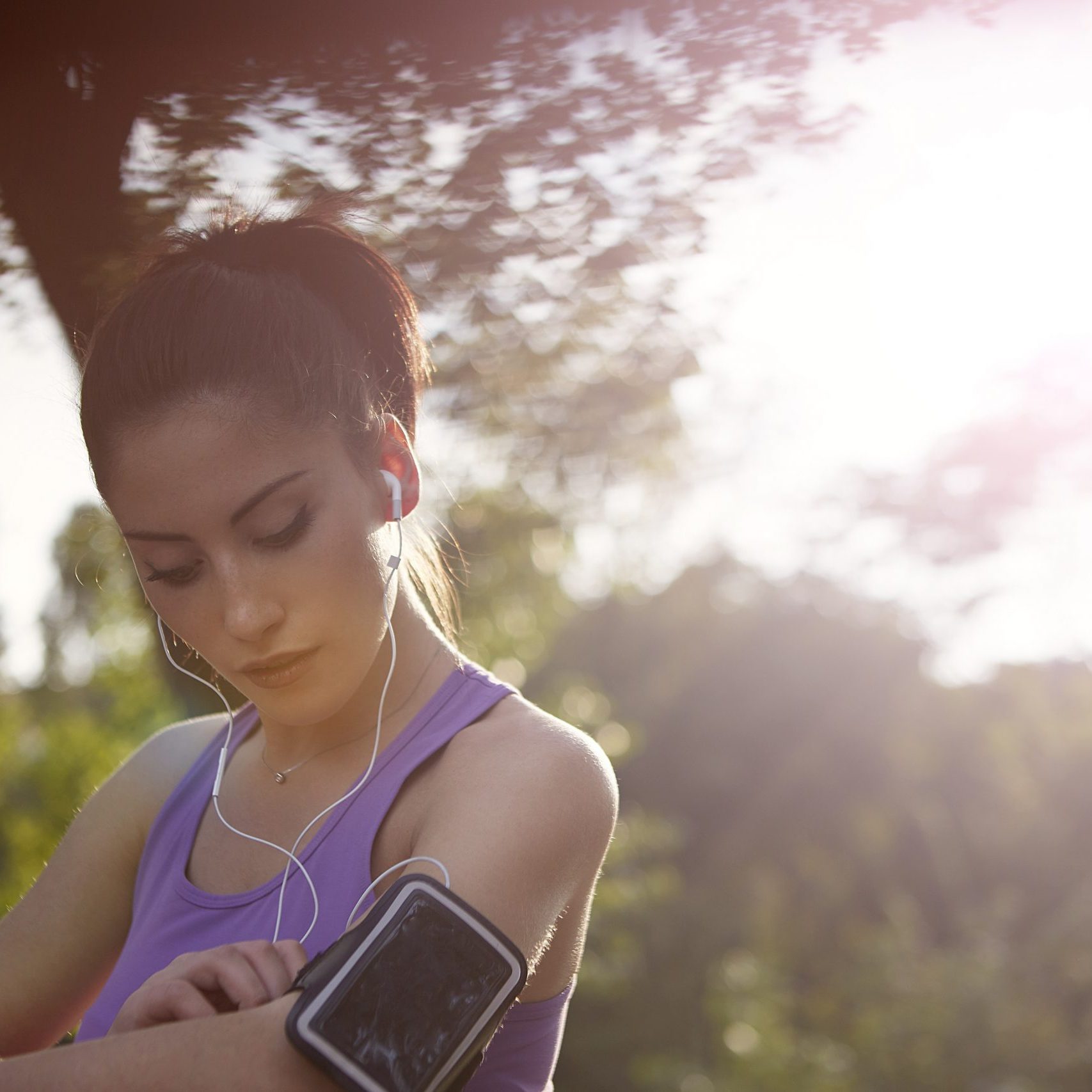 young-sportswoman-listening-to-music-in-park-3776837